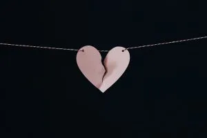 Domestic Partnership Agreements. Support when the relationship ends.  Broken pink heart on gold chain necklace.