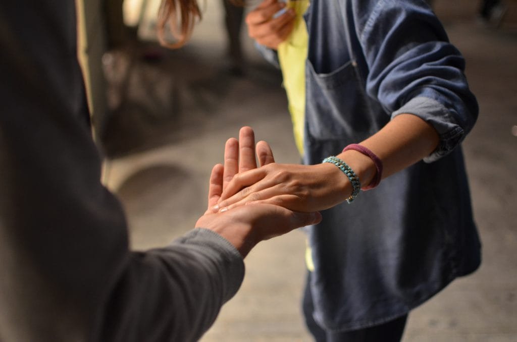 Two people grasping hands in agreement. Domestic partnership agreements FAQs