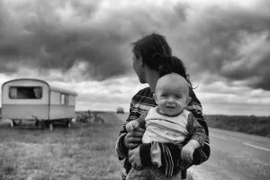 Habitual Residence of the Child. Grayscale photography of woman holding baby while looking back at trailer. Johann Walter Bantz (Unsplash).